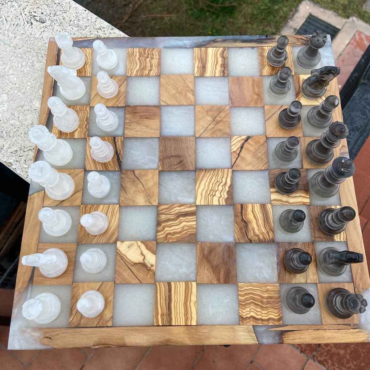 Vista dall'alto della nostra scacchiera artigianale in legno e resina, con i pezzi bianchi e neri schierati. Made in Italy da Marco Morrone wood and resin design.