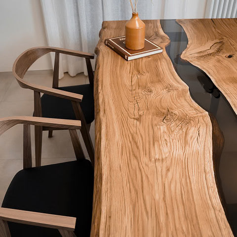 Tavolo river table artigianale in legno massello e resina epossidica scura ambientato con sedie realizzato a Roma